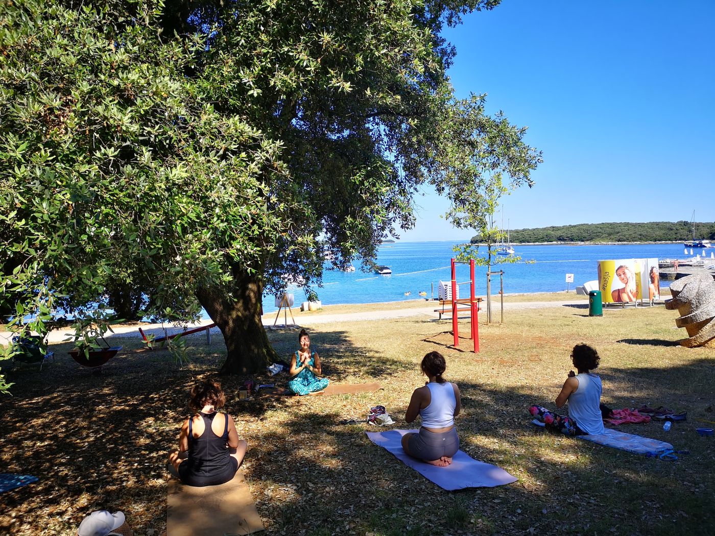 Summer yoga class on the beach in Vrsar, with the sea behind the group